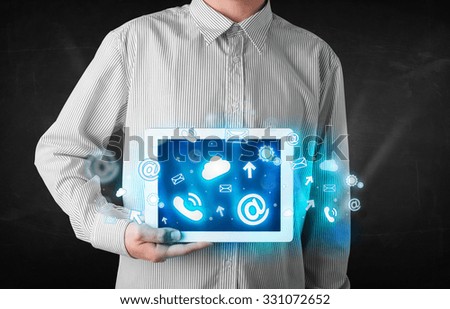 Person holding a white tablet with blue technology icons and symbols