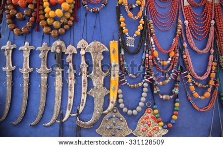 A display of Moroccan and African jewelry and daggers for sale in the souks of Marrakesh, Morocco. Royalty-Free Stock Photo #331128509
