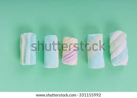 marshmallow candies in different colors on the background of turquoise. top view. entertainment for children in celebration.