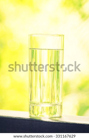 Water glass with outdoor view - vintage filter effect