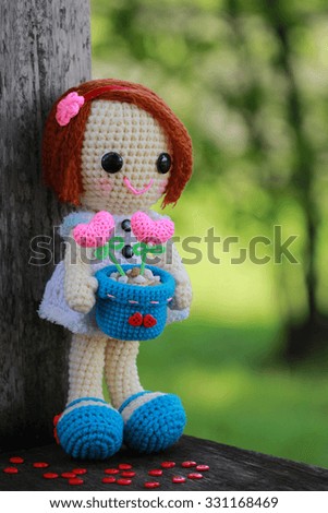 handmade crochet little girl and heart doll on green background