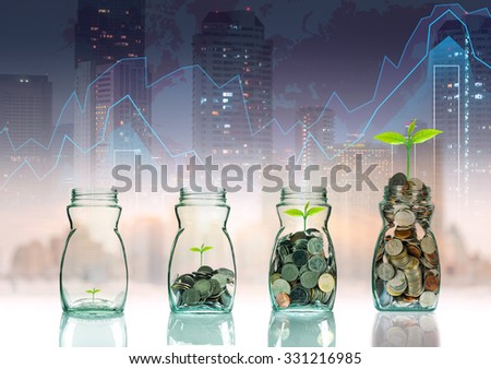 Mix coins and seed in clear bottle on trading graph with cityscape background,Business investment growth concept