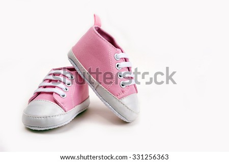 Cute pink baby girl sneakers close up on gray background Royalty-Free Stock Photo #331256363