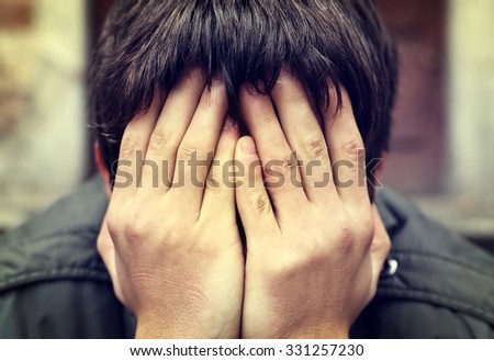 Toned Photo of Sad Man with hidden Face closeup Royalty-Free Stock Photo #331257230