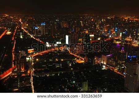 Beautiful and dramatic night cityscape of Bangkok, Thailand's national capital, with highrise buildings and brightly lit highways.