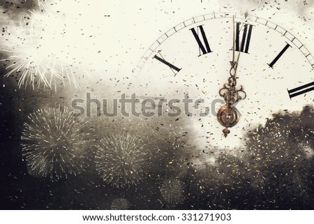 New Year's at midnight - Old clock with fireworks and holiday lights Royalty-Free Stock Photo #331271903