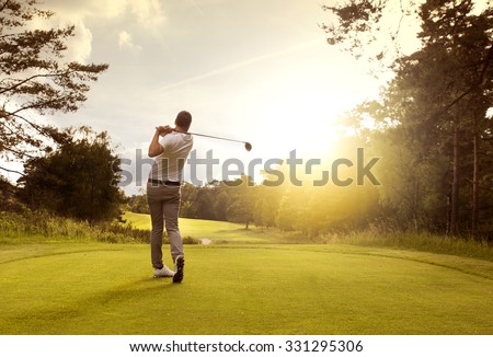 Man playing golf on a golf course in the sun Royalty-Free Stock Photo #331295306