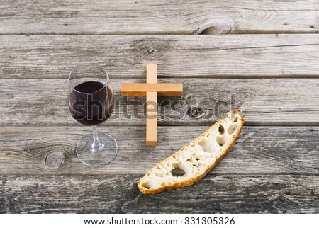 wooden cross and red wine with a slice of bread on old wood table