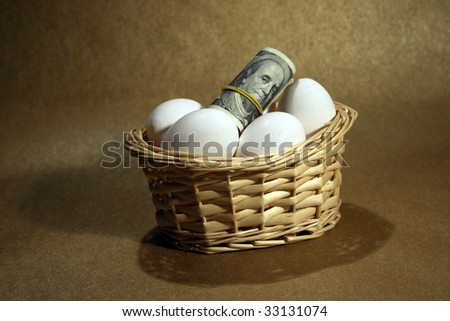 Roll of dollars in basket with eggs stock photo