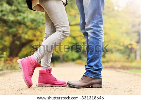 A picture of couple's legs in the park in autumn