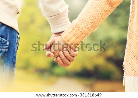 A picture of a couple holding hands in the park