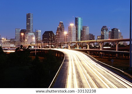 Lighted Houston skyline against blue sky
