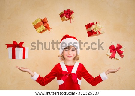 Child juggling Christmas gift boxes. Xmas holiday concept