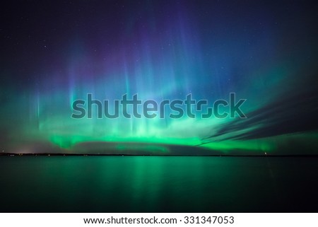 Beautiful northern lights aurora borealis over lake in finland Royalty-Free Stock Photo #331347053