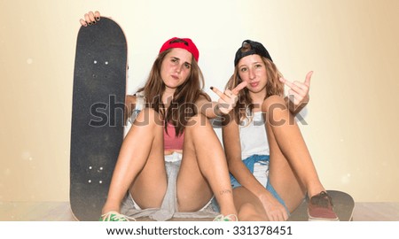 Friends with their skateboards making horn gesture