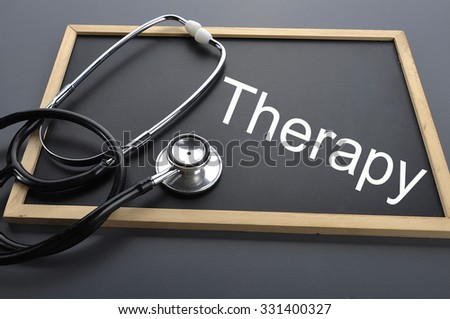 Therapy word with Stethoscope on blackboard - health concept. Medical conceptual. Low-light style