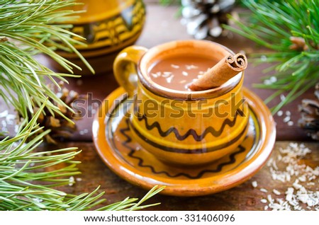 Hot chocolate with cinnamon in a rustic ware. Christmas decoration.