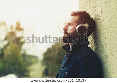 stylish bearded man  in headphones listening to music Royalty-Free Stock Photo #331410137