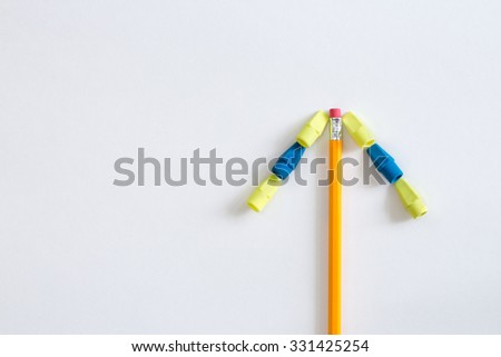A school pencil and erasers used to make a simple arrow on a white horizontal background. This photo can be used as a vertical, horizontal or flipped and put into any position pointing up or down.