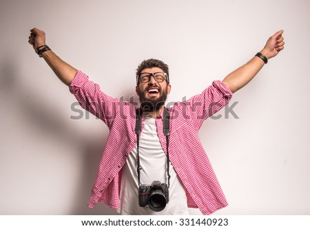 Young cheerful photographer with beard, while working in studio