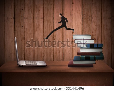 Concept of technology migration with business person jumping from book to laptop