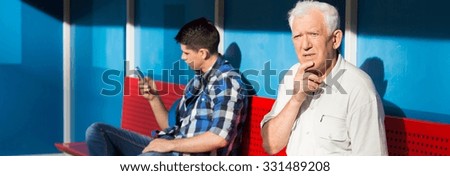 Older confused man and young boy on a bus stop Royalty-Free Stock Photo #331489208