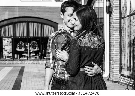Young happy couple staying hugging on street background.