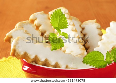 detail of fluted cookies with lemon glazing in red bowl