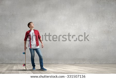 Handsome teenager cool acive boy with skateboard in hand
