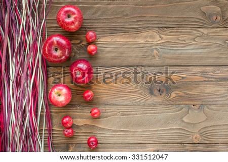 ripe red apples  on wooden table with decorative colorful  dry straw. top view. free space for text