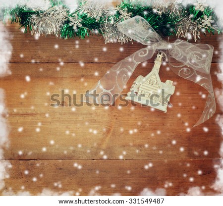 image of christmas festive decorations on wooden background. retro filtered with abstract snowflakes overlay