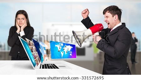 Businessman stands near laptop with many screens and scream to loudspeaker. Elements of this image furnished by NASA