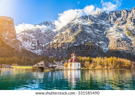 Panoramic view of scenic mountain scenery with Lake Konigssee with famous Sankt Bartholomae pilgrimage church in golden evening light in fall, national park Berchtesgadener Land, Bavaria, Germany Royalty-Free Stock Photo #331585490