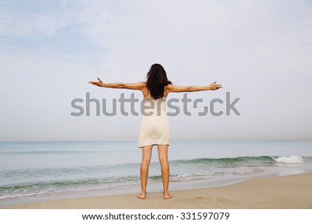 beautiful woman standing on the shore of the beach