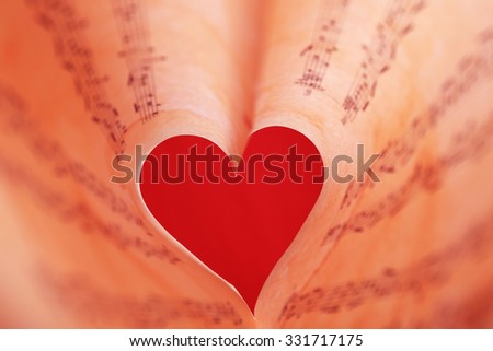Book pages curved into heart shape close up