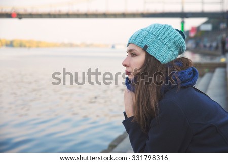 girl sitting on the bank of the river