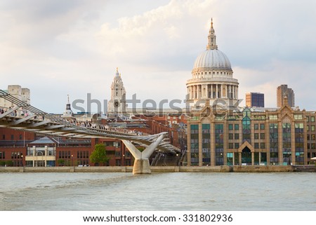 St Paul Cathedral and Millennium bridge with people in London afternoon, natural colors