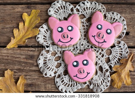 Homemade gingerbread cookie - three little piggies with autumn leaves on the wooden table. Space for text and selective focus.