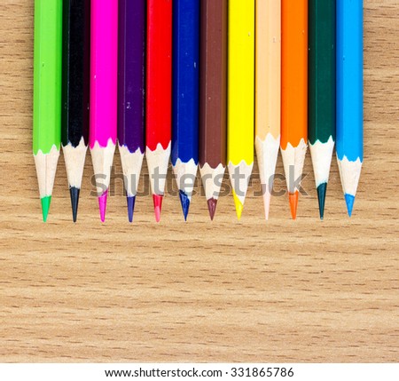 colored pencils on the wooden table clous-up