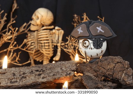 Halloween Devil Doll on black background withhuman skeleton, dead trees and fire.