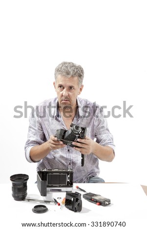 Man repairing an old camera
Male repairing an old camera at his workplace on white background