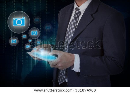 Businessman hand touch camera icons on a tablet.