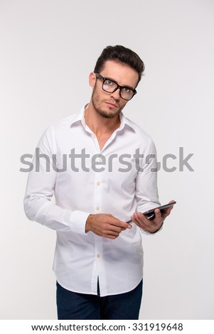 Portrait of a oyung businessman holding tablet computer and looking at camera isolated on a white background