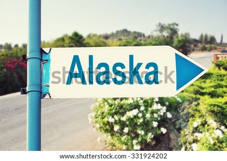 Alaska Road Sign with beautiful nature and road on background. United States of America