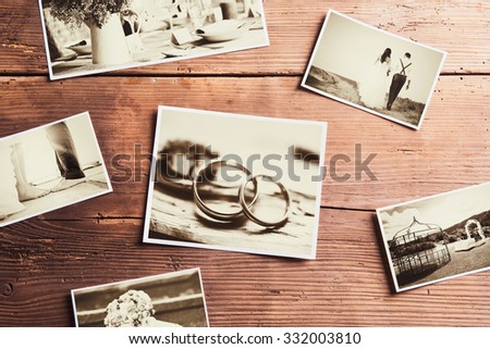 Wedding photos laid on a table. Studio shot on wooden background.