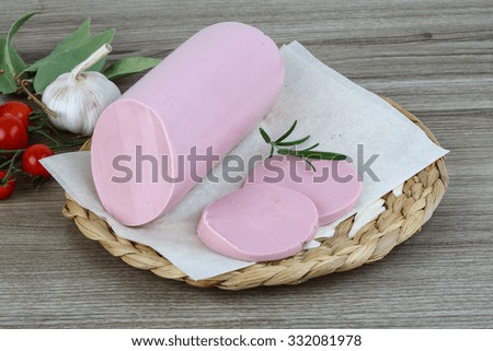Boiled sausage with rosemary on the wood background