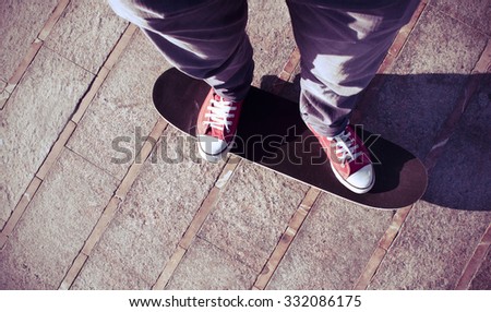 self-portrait of a young man wearing red sneakers on a skate board