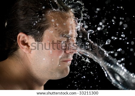 water splash on Man face isolated on black