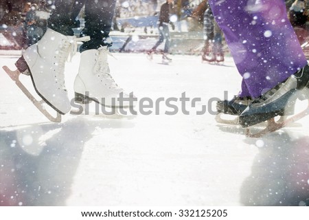 Closeup skating shoes ice skating outdoor at ice rink. Magical glitter of snowy snowflakes and bokeh. Healthy lifestyle and winter sport concept at sports stadium.