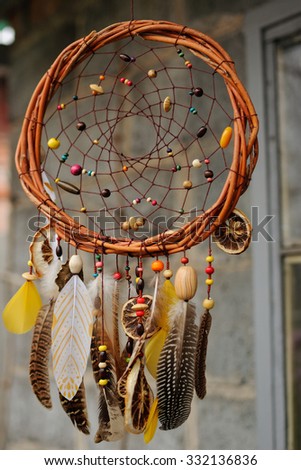 Handmade brown dream catcher at wall in background